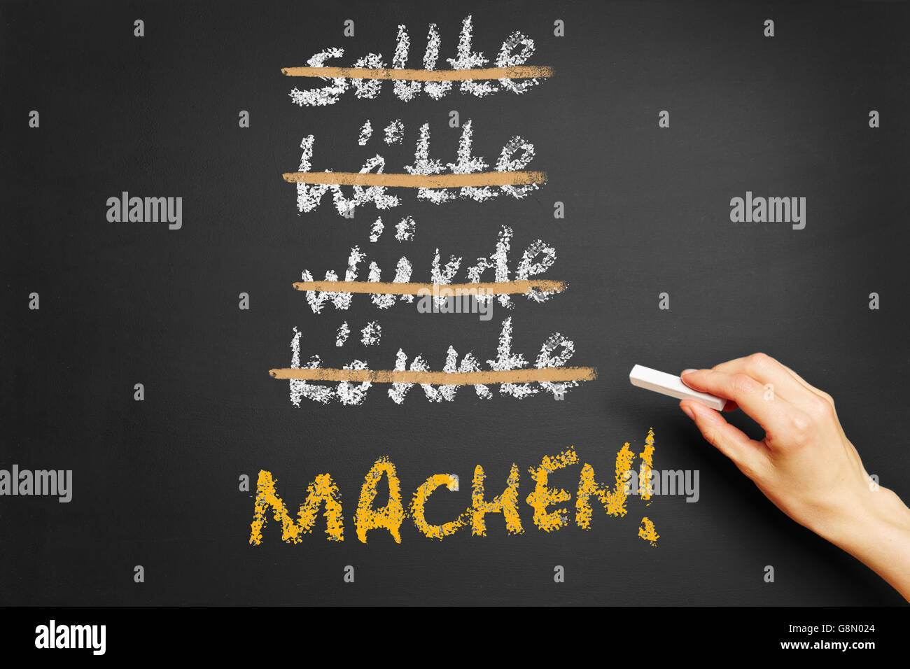 Hand writing motivational slogan in German (Do It) on a chalkboard Stock Photo