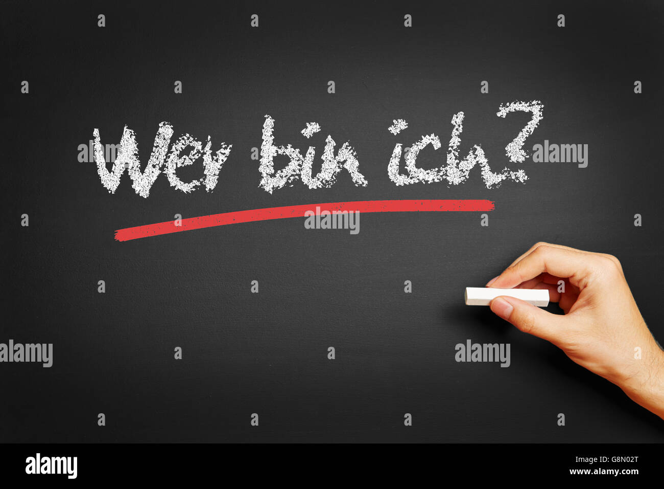 Hand writes in German 'Wer bin ich?' (Who am I?) on blackboard Stock Photo