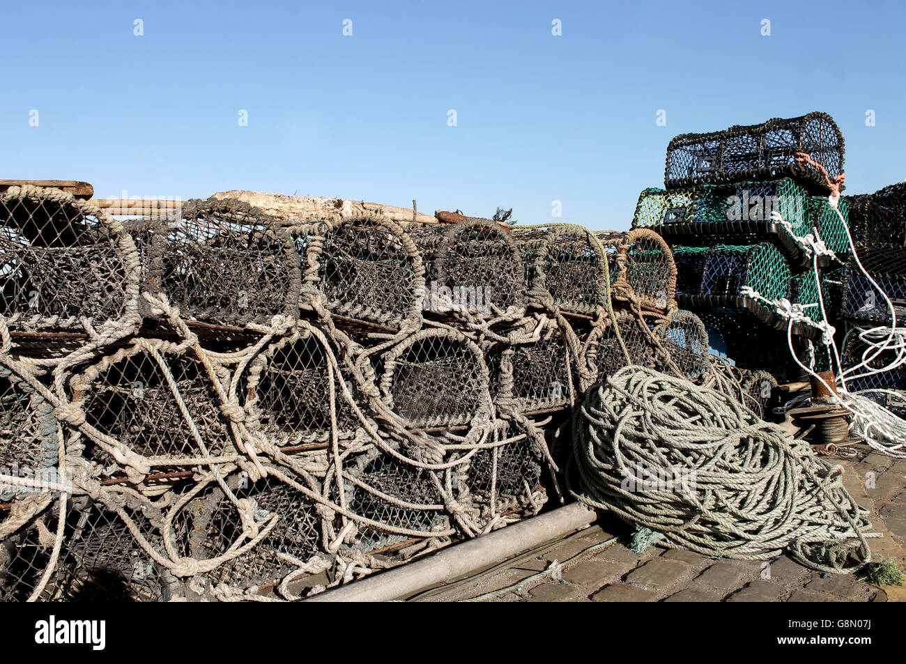 Lobster pots and fishing nets on a harbor quayside. Stock Photo