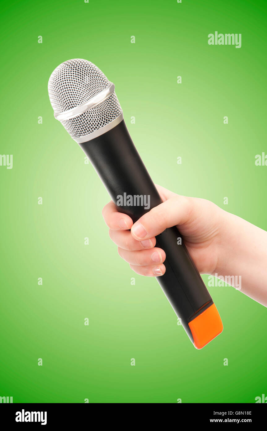 Human Hand with Microphone on Green Background Stock Photo