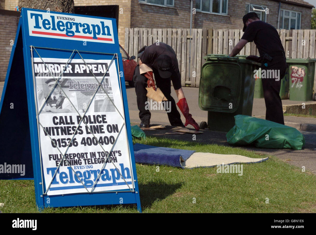 Police search rubbish bins close to a house in Eastbrook, Corby, Northants, after a woman was murdered in the house as a two-year-old child slept upstairs. Wednesday August 31 2005. The toddler, who was unharmed, was found in the property at the same time. See PA Story POLICE Baby PRESS ASSOCIATION PHOTO Photo credait should read: Chris Radburn/PA Stock Photo