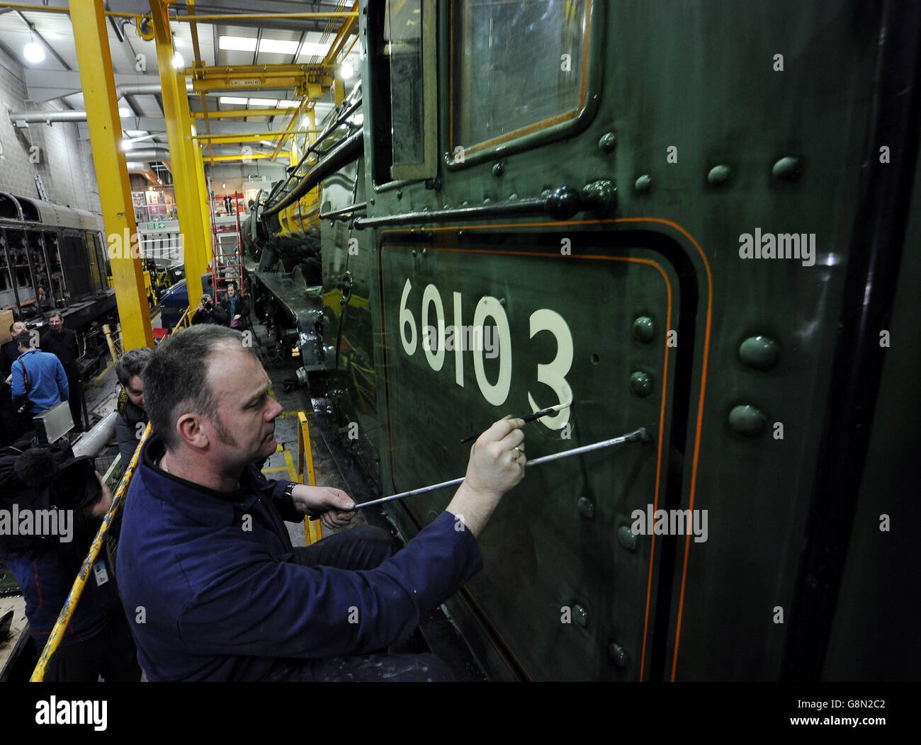 Heritage painter Mike O'Connor paints in the engine number onto the new green livery of the Flying Scotsman ahead of its official return to steam next week, in a workshop at the National Railway Museum in York. Stock Photo