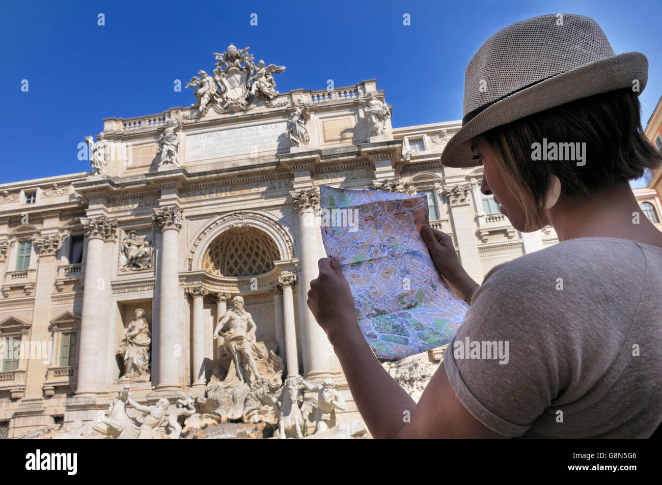 Female tourist with a map, in front of Trevi Fountain, Rome, Lazio, Italy, Europe Stock Photo
