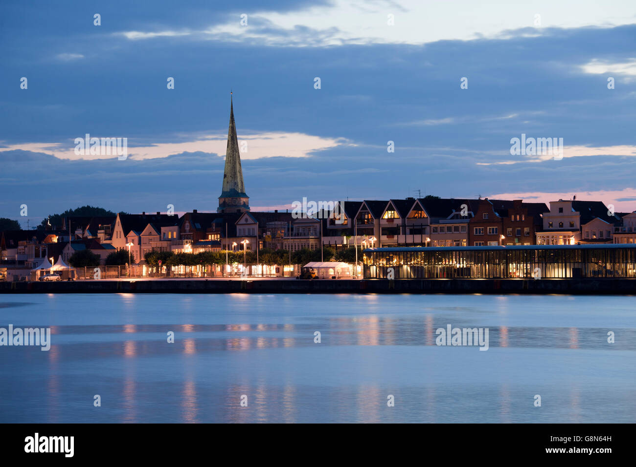 Ostpreußenkai, front row of buildings with St. Lawrence Church, night, blue hour, Baltic coastal resort of Travemuende Stock Photo