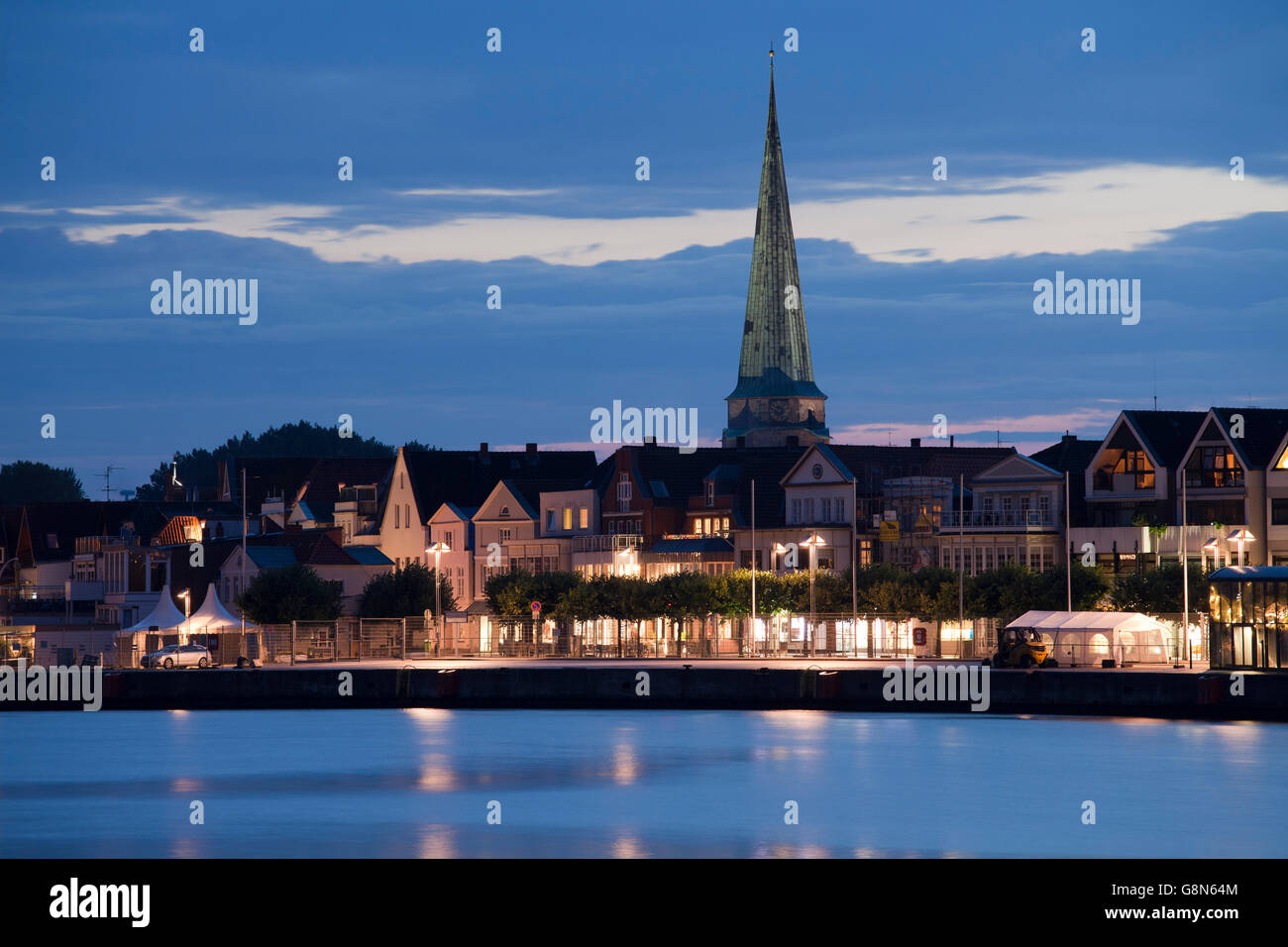 Ostpreußenkai, front row of buildings with St. Lawrence Church, night, blue hour, Baltic coastal resort of Travemuende Stock Photo