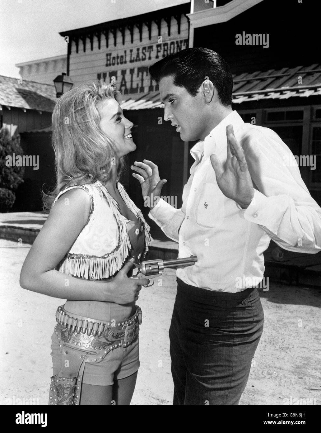 Elvis Presley has a gun playfully aimed at him by co-star Ann-Margret on the set of MGM's latest picture, 'Viva Las Vegas'. Stock Photo