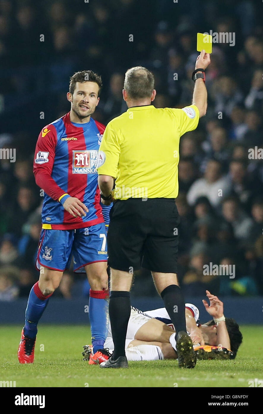 Crystal Palace's Yohan Cabaye receives a yellow card for a tackle on West Bromwich Albion's Claudio Yacob, who lies injured, during the Barclays Premier League match at The Hawthorns, West Bromwich. Stock Photo