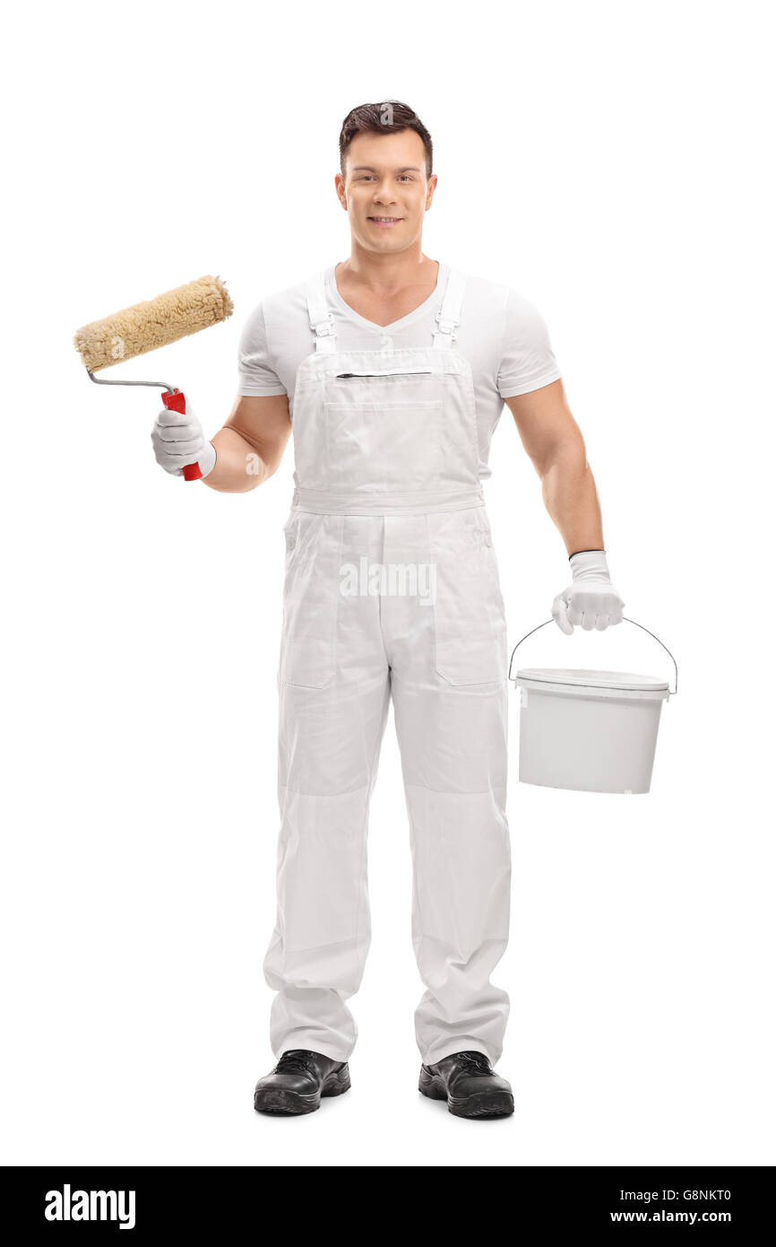 Full length portrait of a young male decorator holding a paint roller and a color bucket isolated on white background Stock Photo