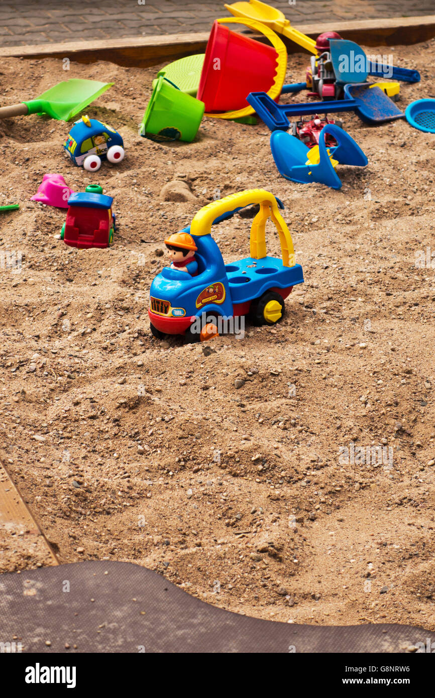 colourful plastic toys scattered in a sandpit Stock Photo