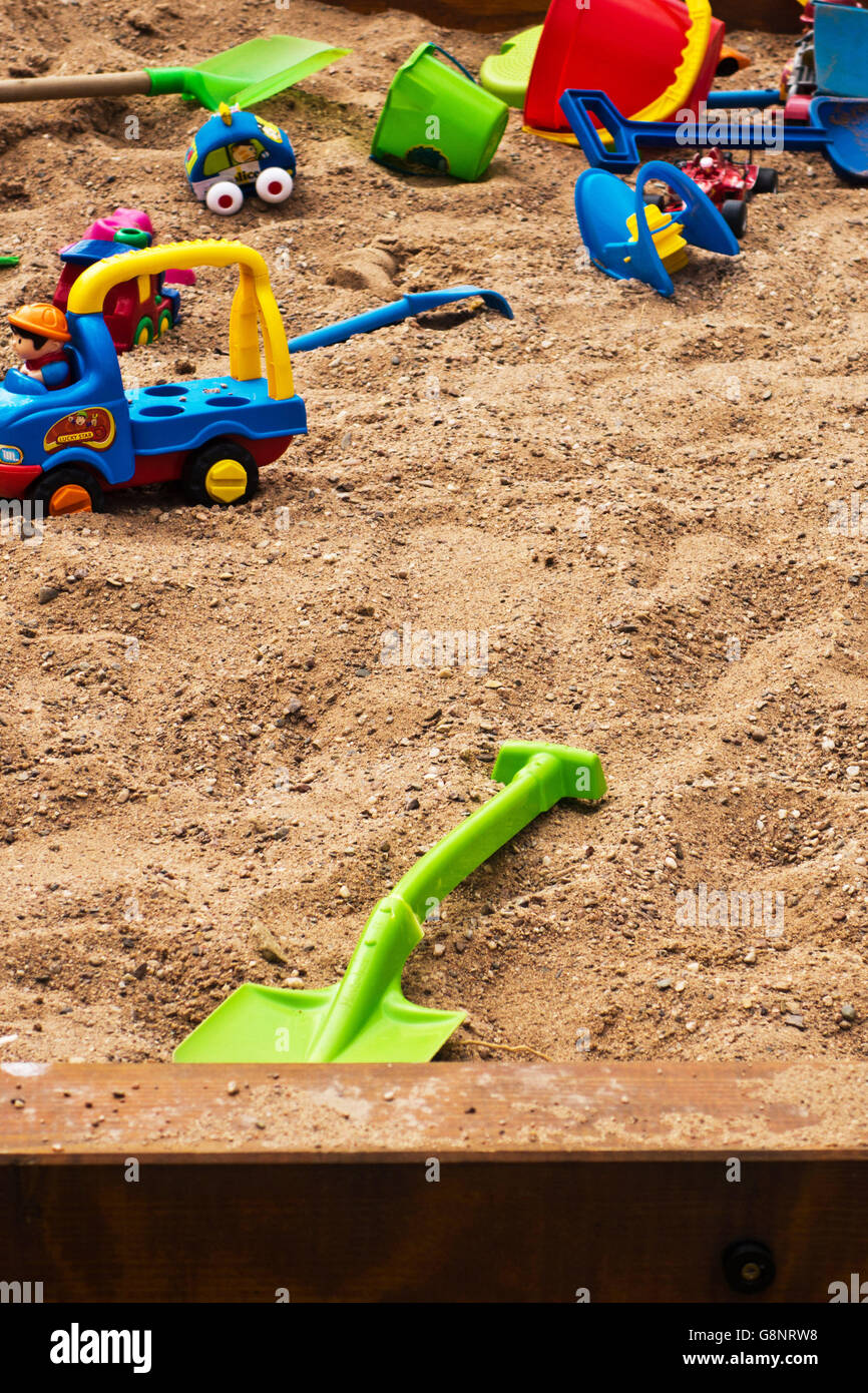 colourful plastic toys scattered in a sandpit Stock Photo