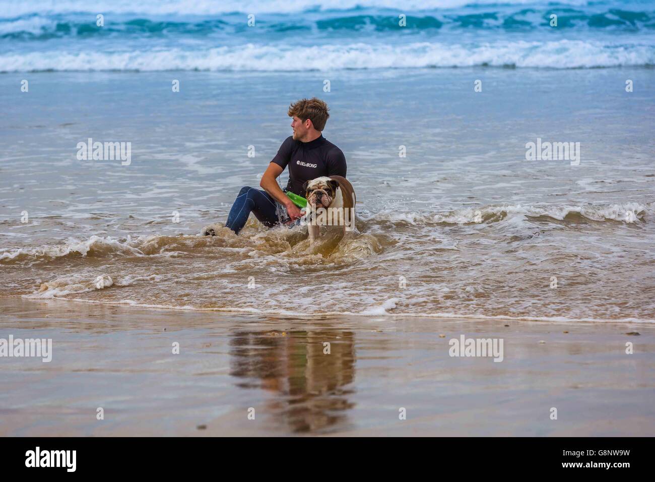 a surfer meets the beach at Fistral Beach, Newquay, Cornwall Stock Photo