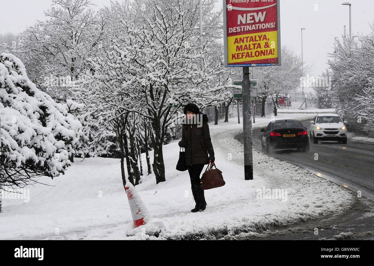 A woman walks through the snow close to Leeds Bradford Airport which was forced to close while crews worked to clear the runway, as parts of the UK woke up to almost four inches of snow on Friday morning as March continues to feel more like winter than spring. Stock Photo