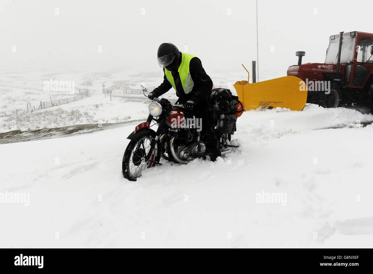 Classic motor cycle enthusiast David Carrick makes his way across the Yorkshire Dales on his way to Dent for a rally as deep snowfalls cover the Pennine tops. Stock Photo