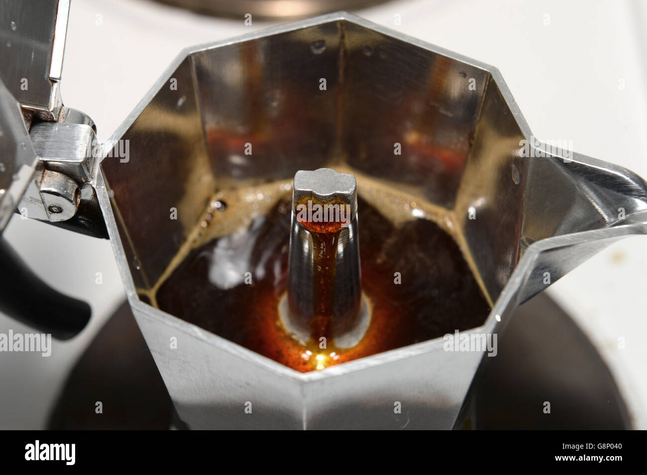 Coffee perculates through a stovetop espresso coffee maker on an