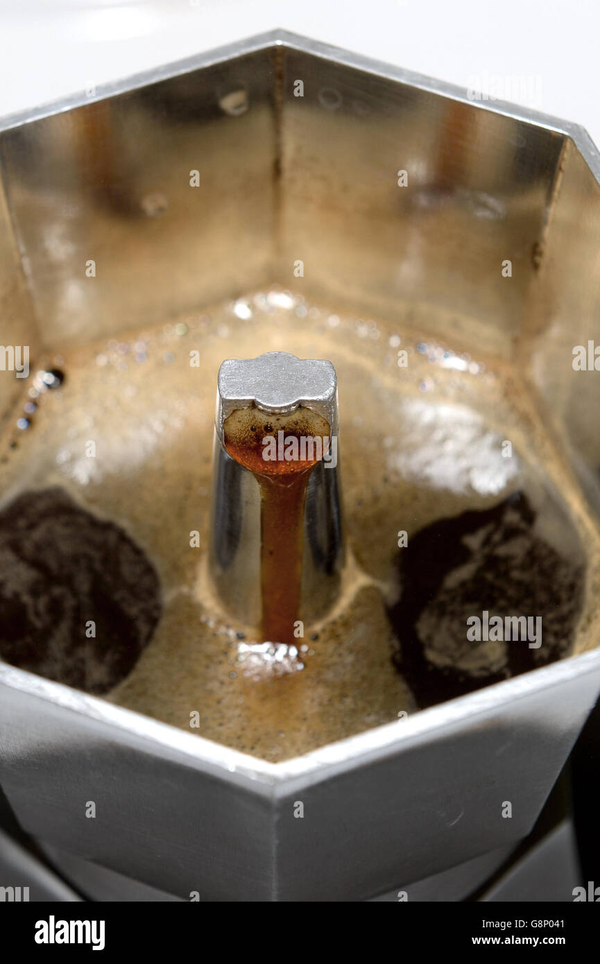 Coffee perculates through stovetop espresso coffee maker on electric