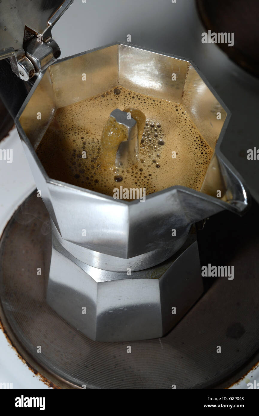 Coffee perculates through a stovetop espresso coffee maker on an