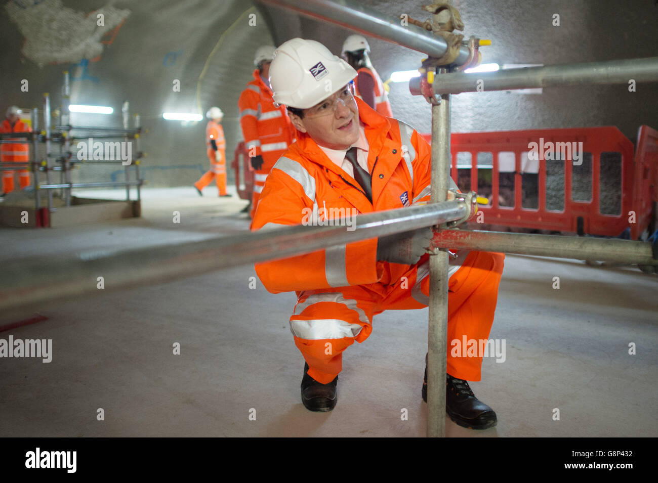 Chancellor of the Exchequer George Osborne visits the Crossrail station construction site at Tottenham Court Road in central London where he helped to build a section of scaffolding and met with engineers. Stock Photo