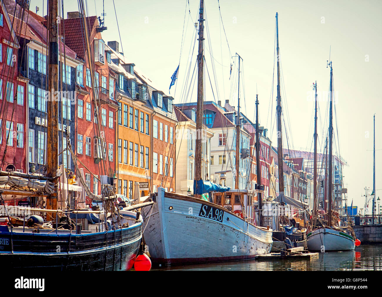 Copenhagen, Nyhavn famous landmark and entertainment district with antique colorful buildings and an old ships moored Stock Photo