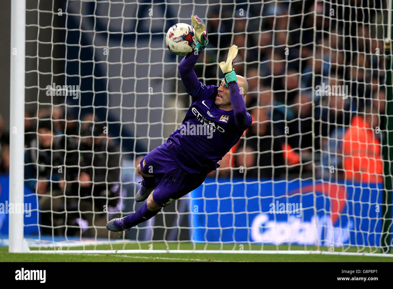 Manchester City goalkeeper Willy Caballero saves a penalty from Liverpool's Lucas Leiva in the penalty shoot-out during the Capital One Cup final at Wembley Stadium, London. Stock Photo