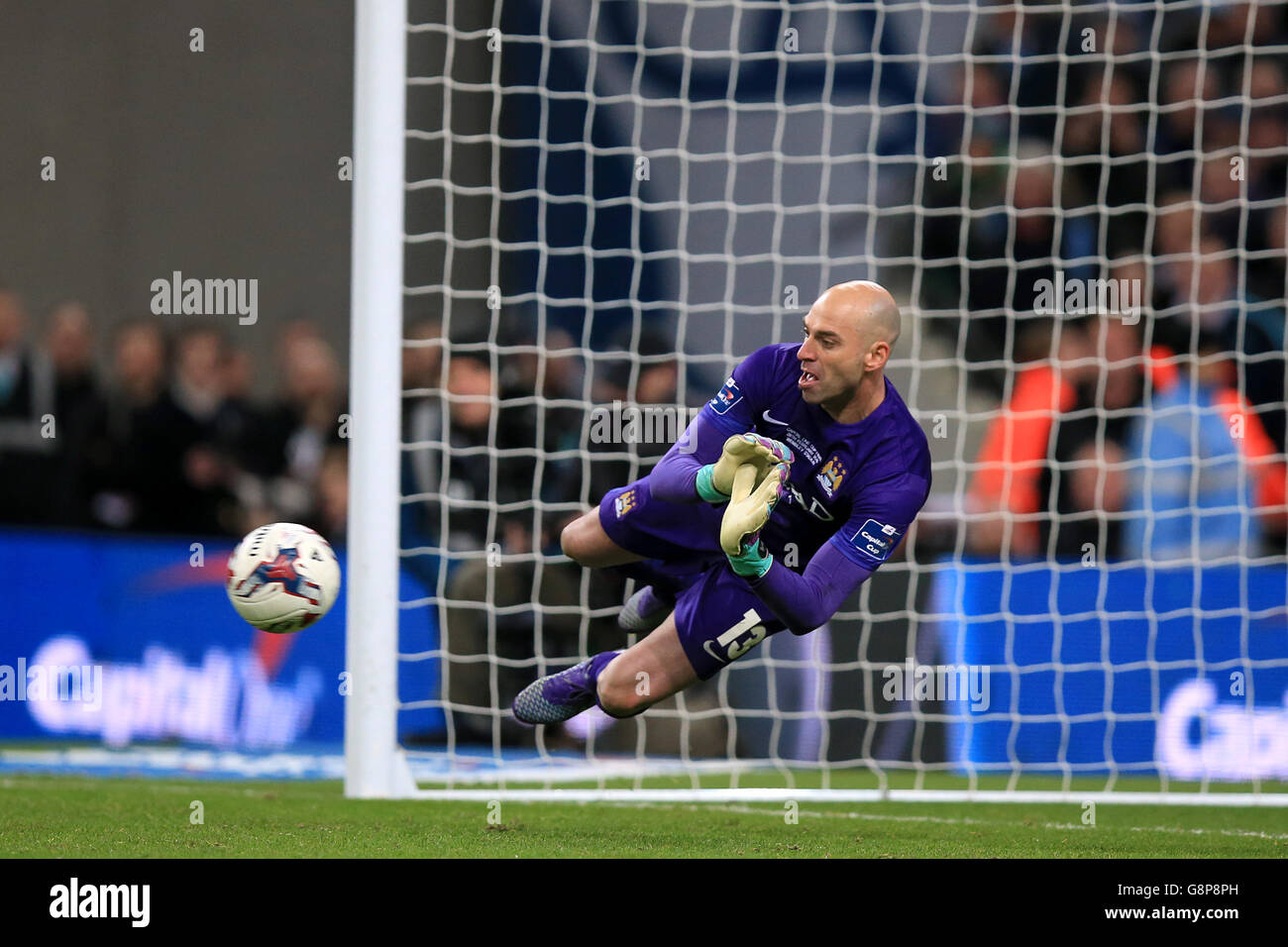 Manchester City goalkeeper Willy Caballero saves a penalty from Liverpool's Philippe Coutinho in the penalty shoot-out during the Capital One Cup final at Wembley Stadium, London. Stock Photo