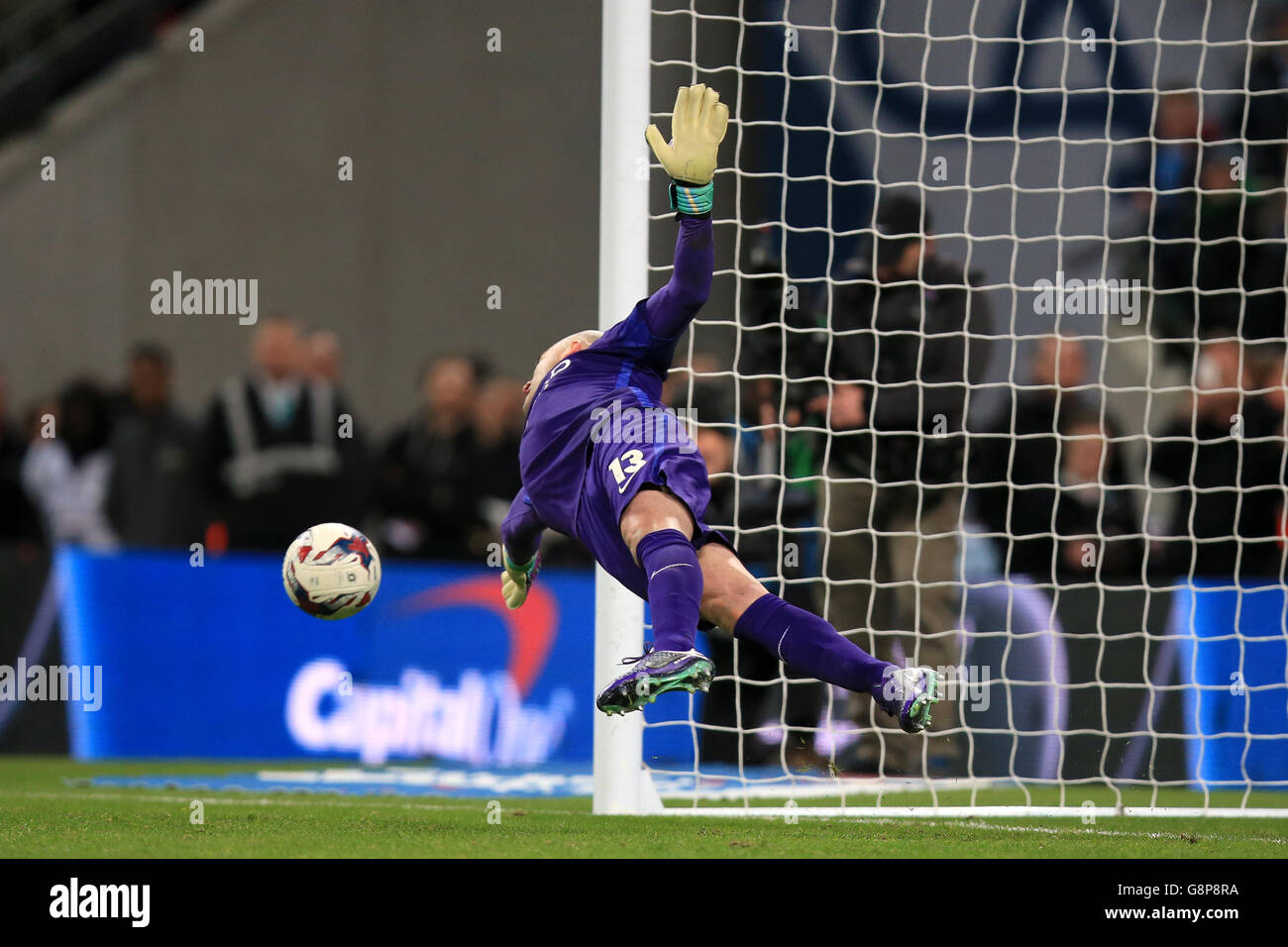Manchester City goalkeeper Willy Caballero saves a penalty from Liverpool's Adam Lallana in the penalty shoot-out during the Capital One Cup final at Wembley Stadium, London. Stock Photo