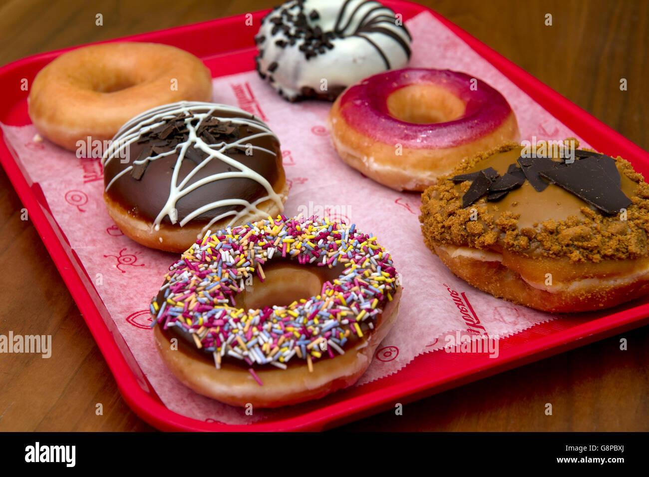 Krispy Kreme selection of donuts with various sweet coatings. a UK dessert desserts sweet sweets confectionery cake cakes donut Stock Photo