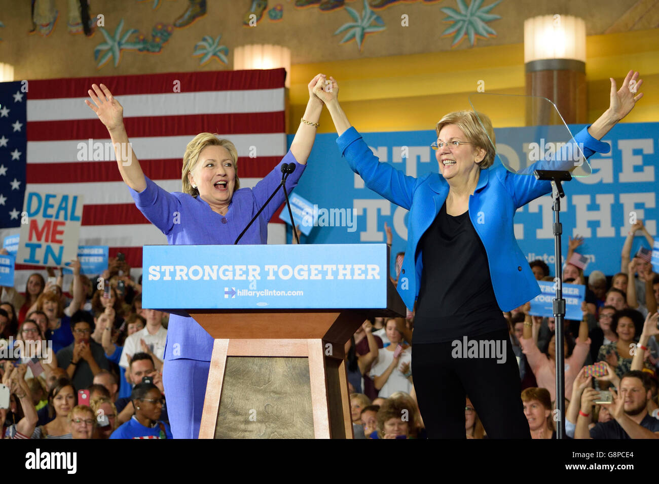 Hillary Clinton and Elizabeth Warren stand on stage holding hands up at a campaign rally in Cincinnati Ohio on June 27, 2016. Stock Photo