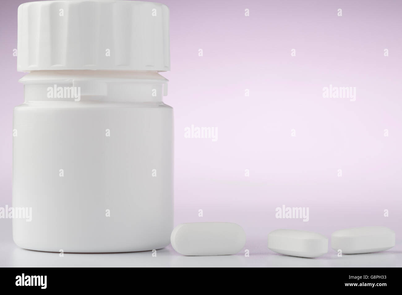 White plastic pill bottle and pills on color background Stock Photo