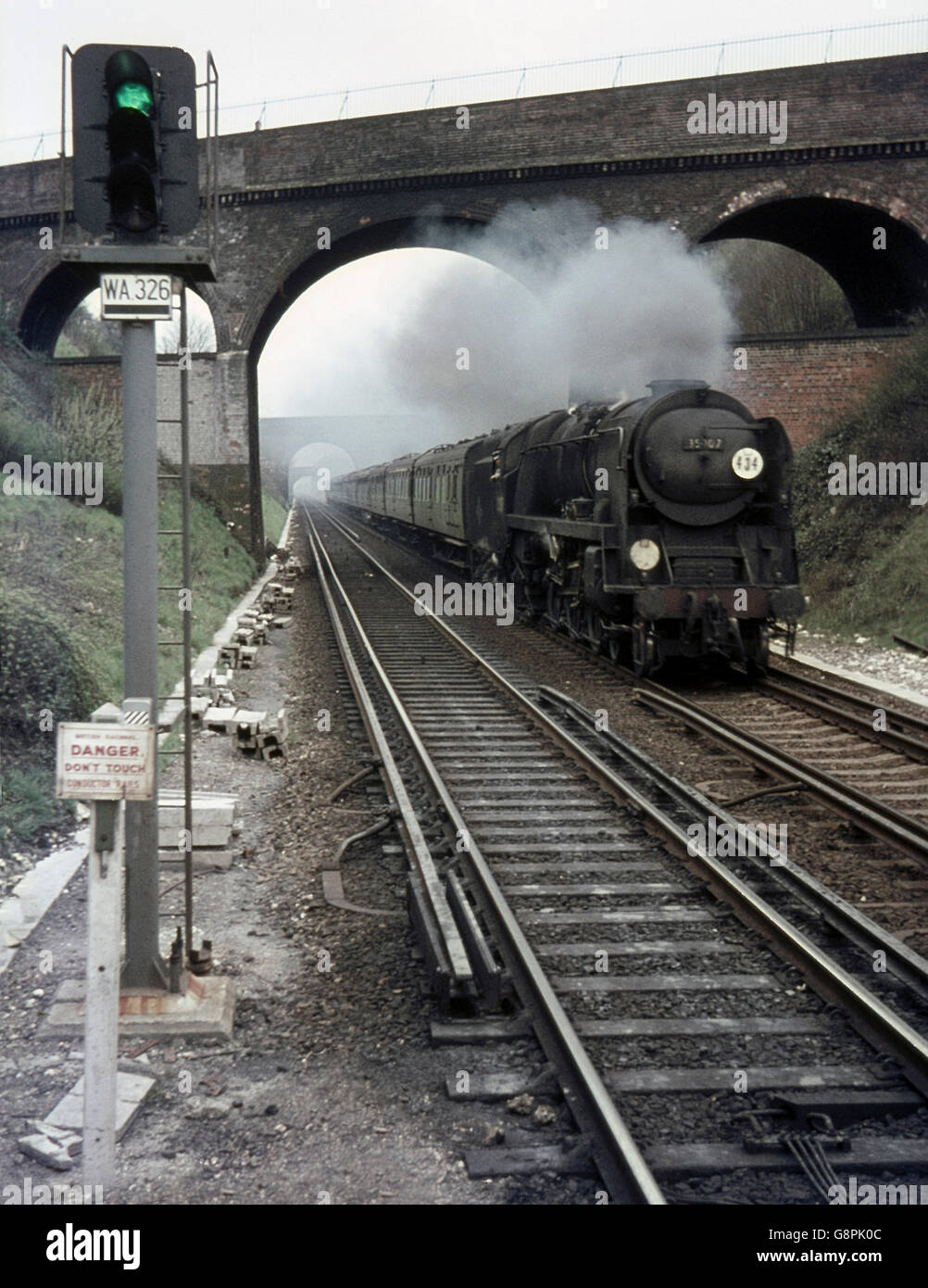 A Bournemouth to London Waterloo express speeds through Winchester, headed by Merchant Navy No. 35007 Aberdeen Commonwealth. Stock Photo