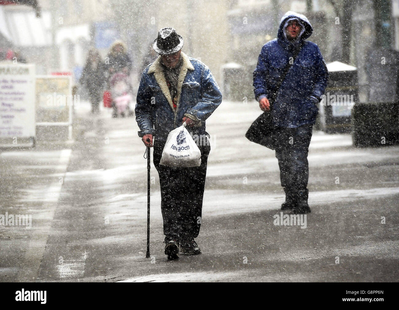 People makes their way through Buxton town centre, Derbyshire, as forecasters said that Storm Jake may bring ice, snow and 70mph winds. Stock Photo