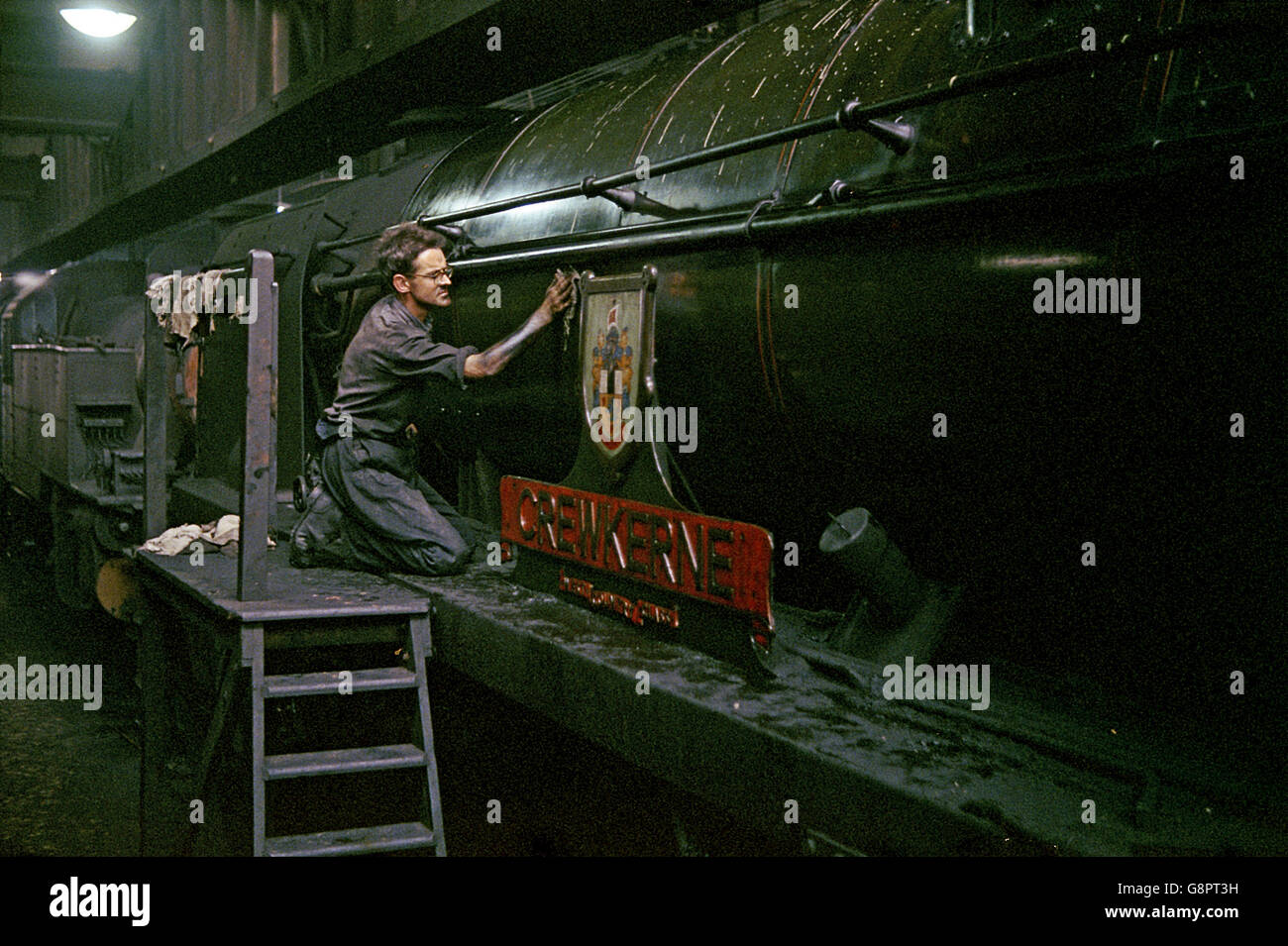 A Shedman applies spit and polish at Salsbury depot to the nameplate of rebuilt Bulleid Pacific No. 34040 Crew Kerne. Stock Photo