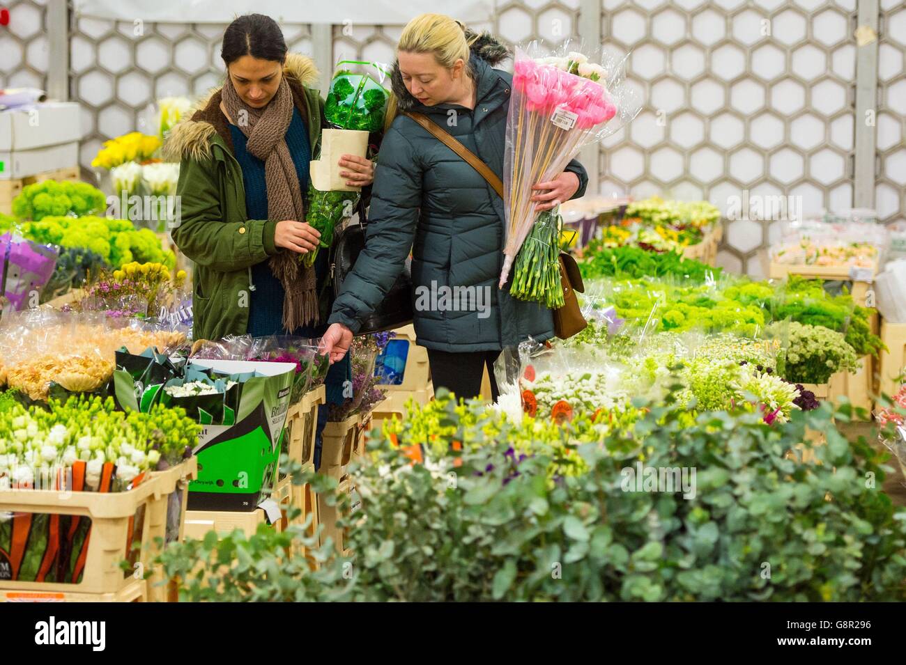 Two women browse produce at New Covent Garden Flower Market, which is the UK's largest wholesale flower market, in Nine Elms, London, ahead of Mothering Sunday this weekend. Stock Photo
