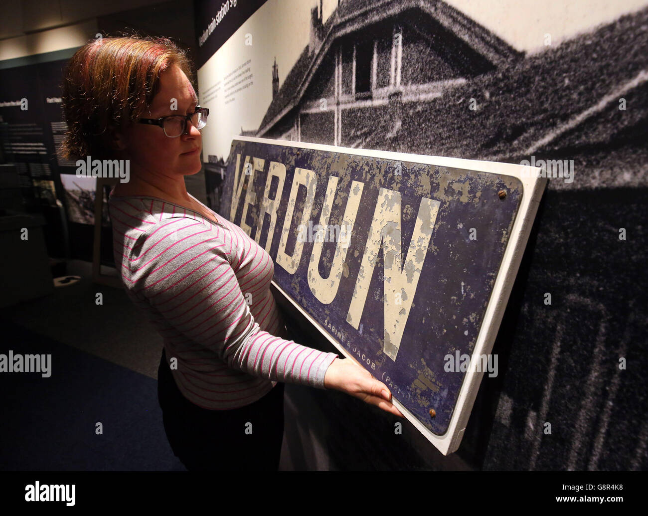 Exhibition Manager Fran Stovold, places an original sign for Verdun, the scene of one of the largest First World War battles on display before an Exhibition entitled Remembering 1916 - Life on the Western Front which opens on the 12th of March at the Whitgift Exhibition Centre in Croydon, London. Stock Photo