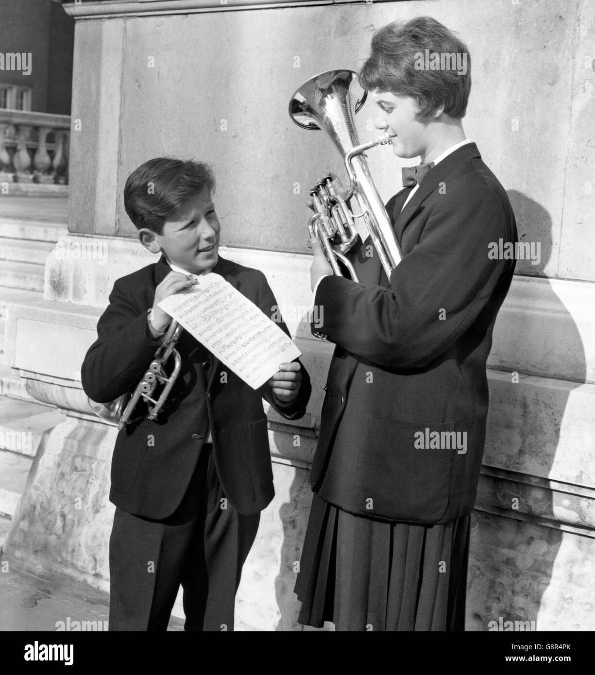 Jack Miller, 12, of the Tullis Russell Mills Band, from Markinch, Fife, holds sheet music for Helen Wheatley, 15, of Fishponds British Legion Band, from Bristol, as she practices at the Royal Albert Hall, London. Jack and Helen were two of the youngest players in the National Brass Band Championships at the Albert Hall. Stock Photo