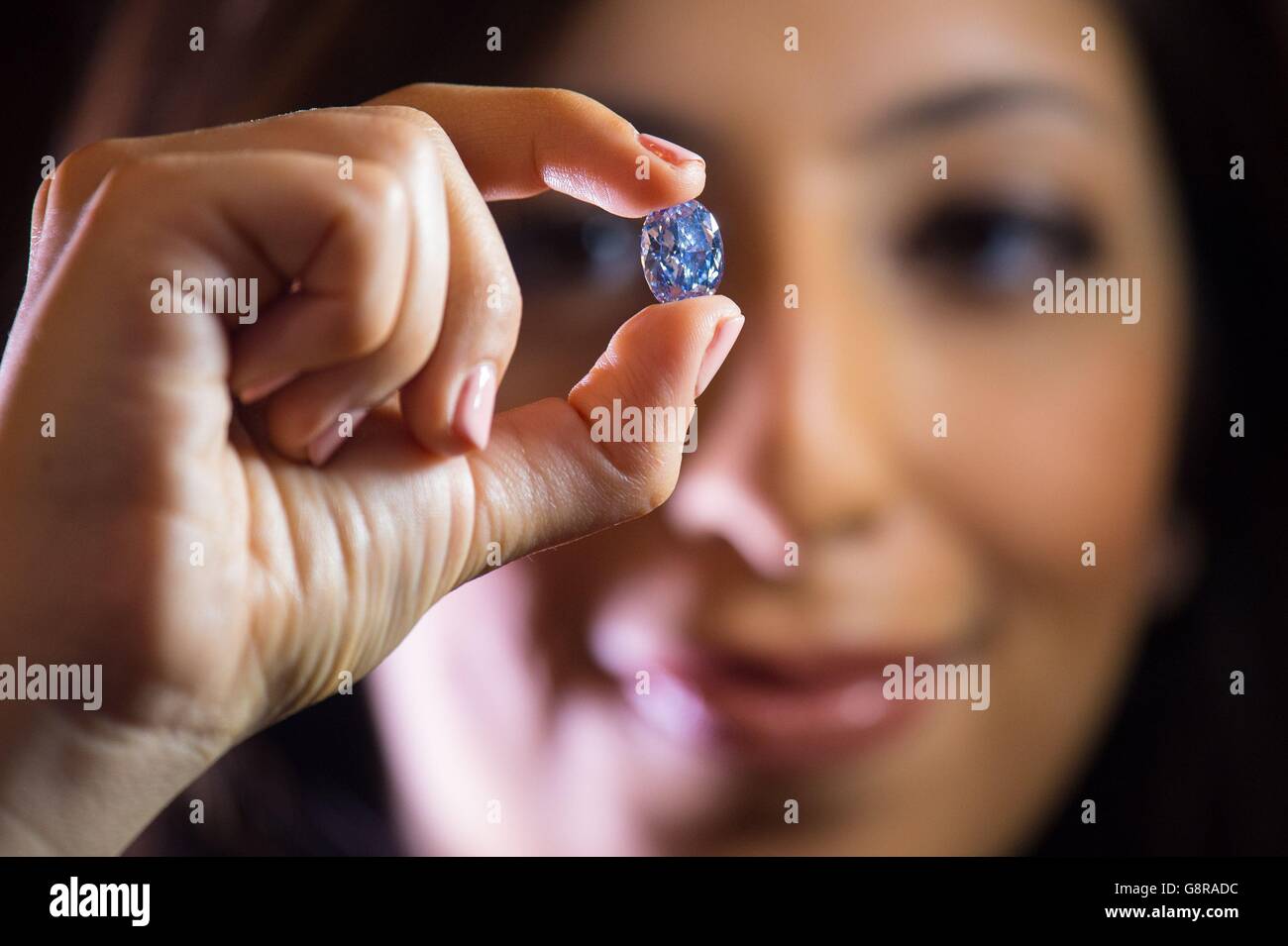 A member of Sotheby's staff holds the De Beers Millennium Jewel, a 10.10 carat 'internally flawless' blue diamond, which is the largest of its type to appear at auction and is estimated to fetch $30 to $35 million when it is sold in Sotheby's Hong Kong Magnificent Jewels and Jadeite Sale on 5 April 2016. Stock Photo
