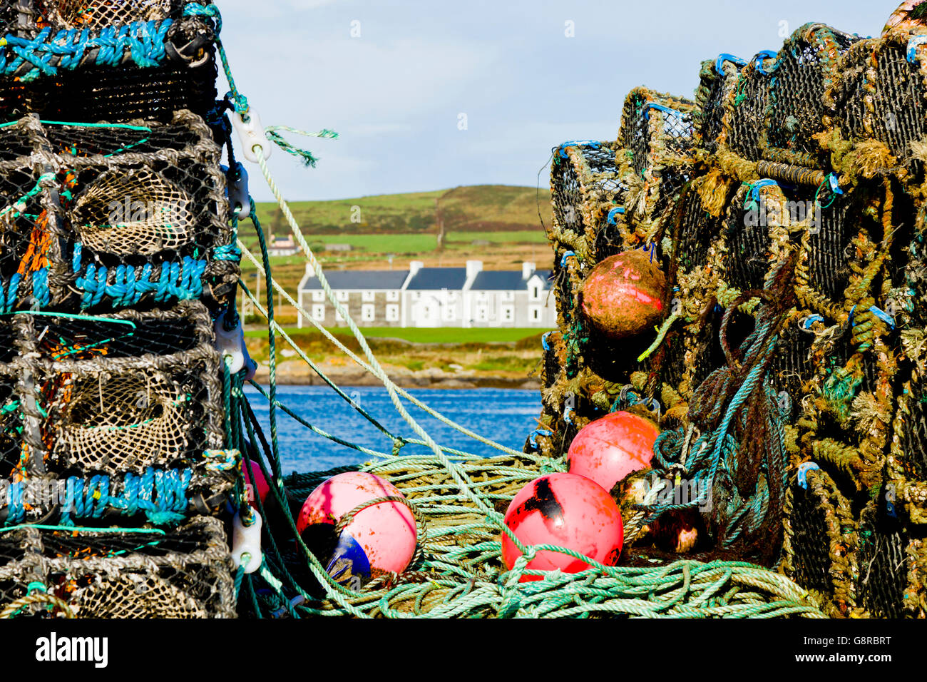 Houses on Valentia Island seen through stacks of lobster and crab pots