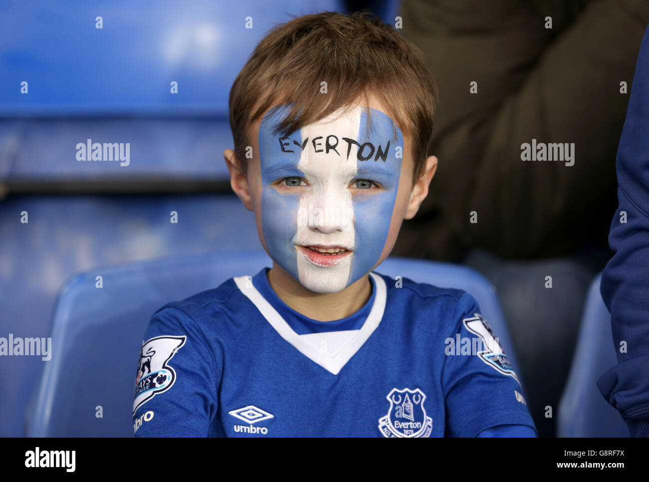 A young Everton fan wearing blue and white face paint during the