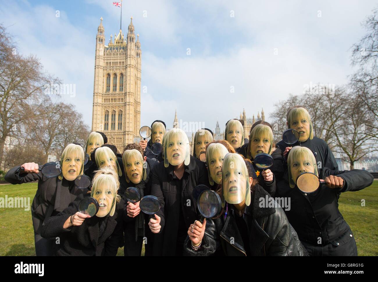Members of the campaign group NoteMyVote.co.uk wearing masks of Home Secretary Theresa May at a photocall outside the Houses of Parliament, in Westminster, London, to protest against the speed with which the Investigatory Powers Bill is being pushed through the House of Commons. Stock Photo