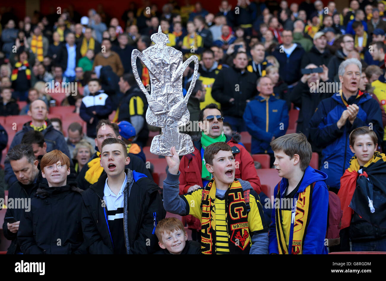 Watford fans with a cardboard FA Cup cutout in the stands during the Emirates FA Cup, Quarter Final match at the Emirates Stadium, London. Stock Photo