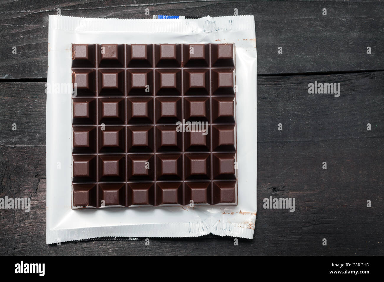 Dark chocolate bar in opened foil wrapping Stock Photo - Alamy