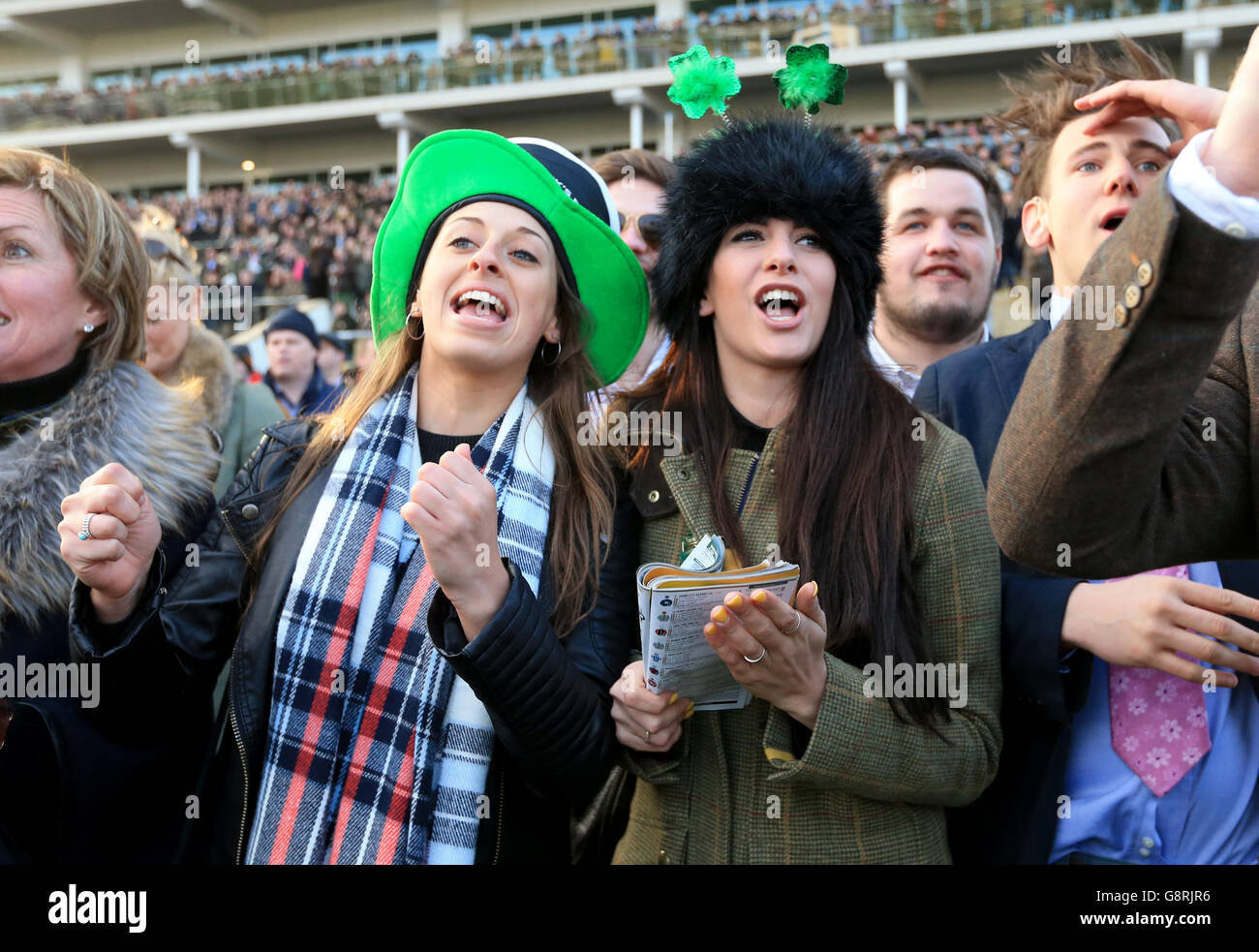 Female racegoers cheer on the horses during the Trull House Stud Mares' Novices' Hurdle during St Patrick's Thursday of the 2016 Cheltenham Festival at Cheltenham Racecourse. PRESS ASSOCIATION Photo. Picture date: Thursday March 17, 2016. See PA story RACING Trull. Photo credit should read: Mike Egerton/PA Wire. Stock Photo