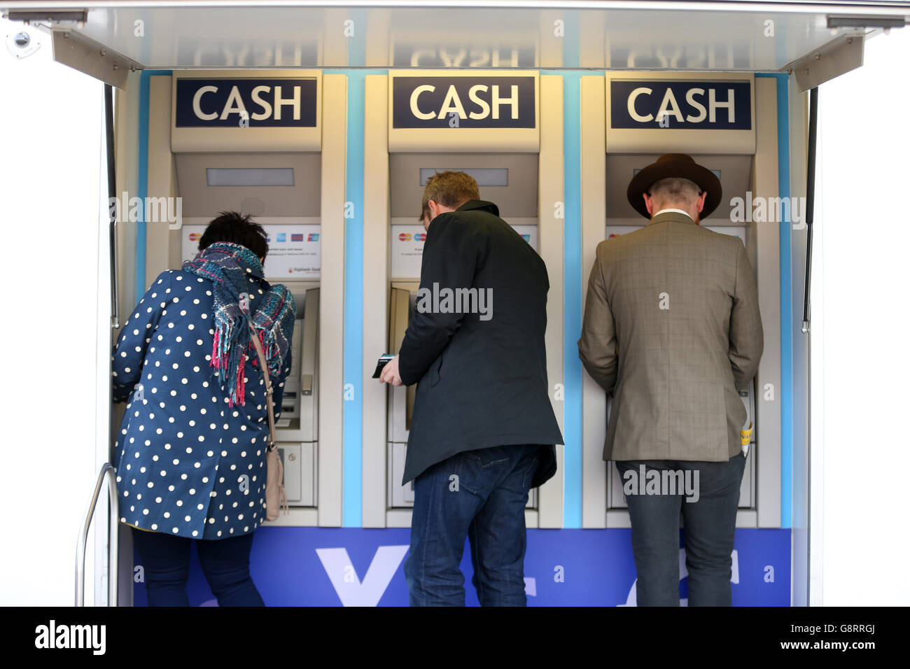 Racegoers withdraw money from the portable cash machine during St Patrick's Thursday of the 2016 Cheltenham Festival at Cheltenham Racecourse. PRESS ASSOCIATION Photo. Picture date: Thursday March 17, 2016. See PA story RACING Cheltenham. Photo credit should read: David Davies/PA Wire. Stock Photo