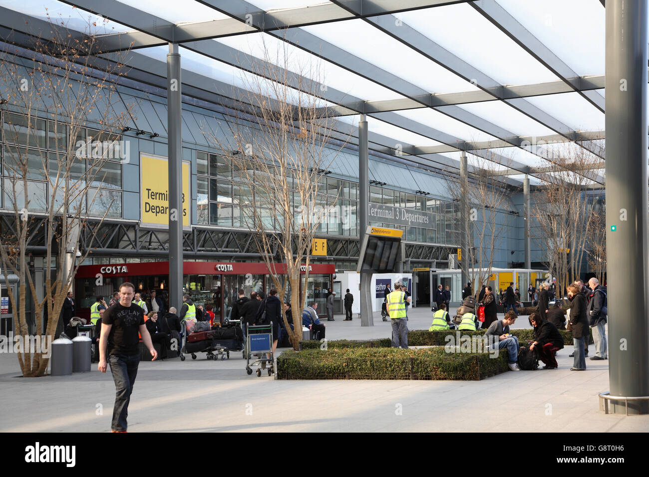 Landside entrance to London Heathrow Airport Terminal 3 Departures hall. Shows external area busy with passengers and staff Stock Photo