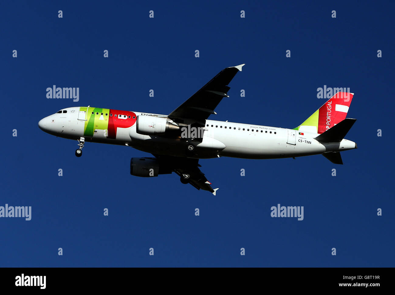 Plane Stock - Heathrow Airport. A TAP - Air Portugal Airbus A320-214 plane with the registration CS-TNN lands at Heathrow Stock Photo