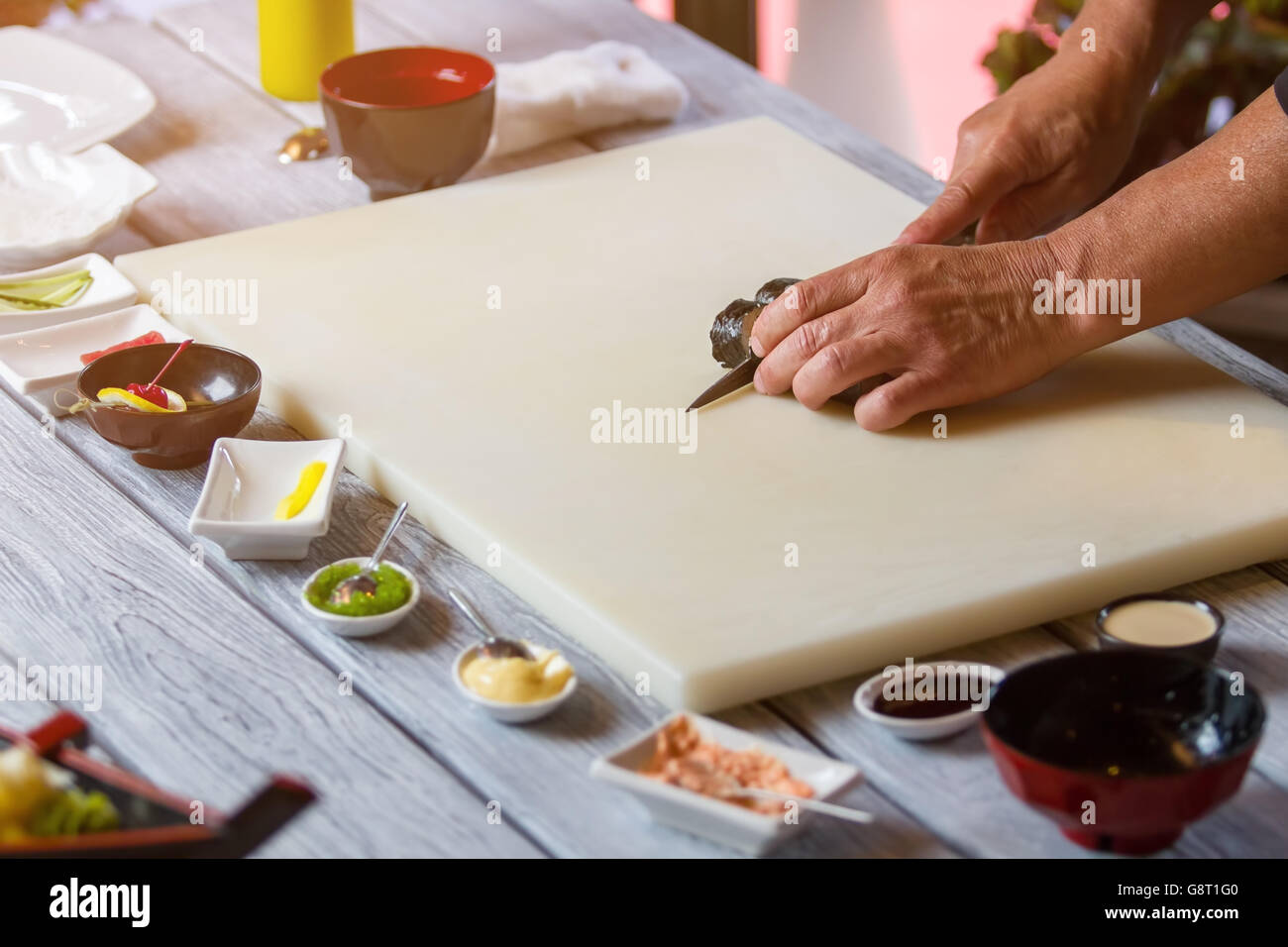 Hands with knife cutting sushi Stock Photo Alamy