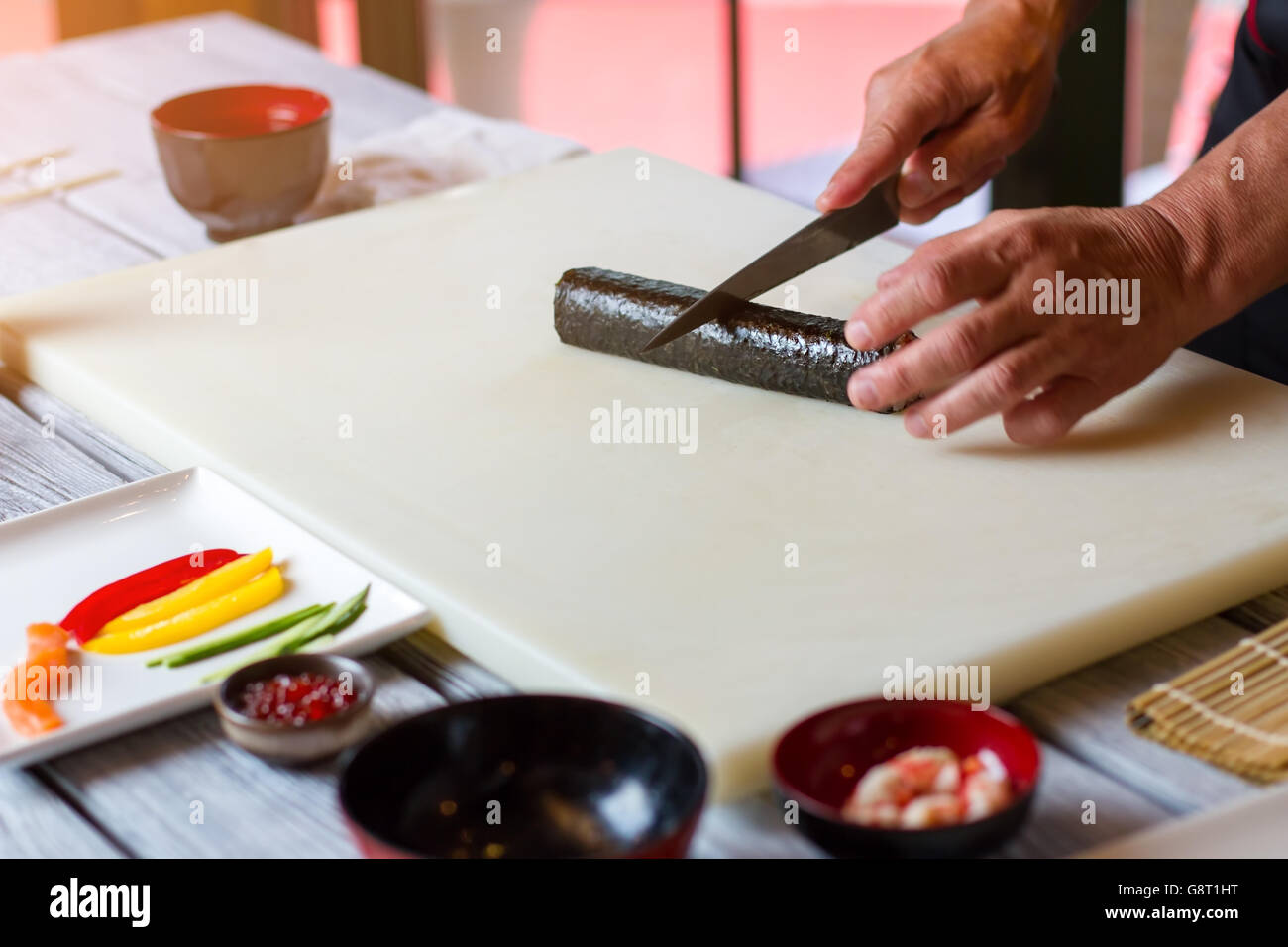 Hand with knife cuts sushi Stock Photo Alamy