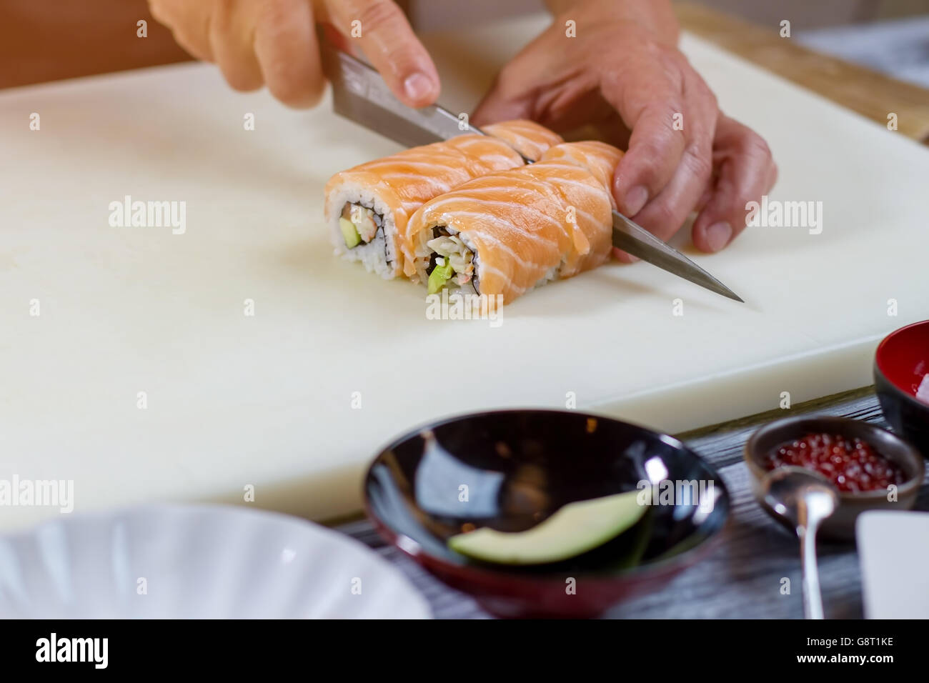 Knife cuts sushi rolls Stock Photo Alamy