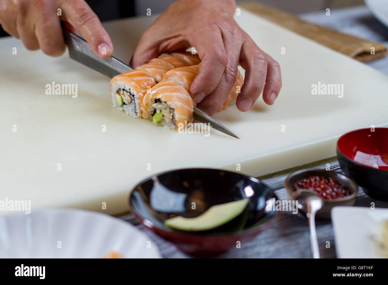 Knife cutting sushi rolls Stock Photo Alamy