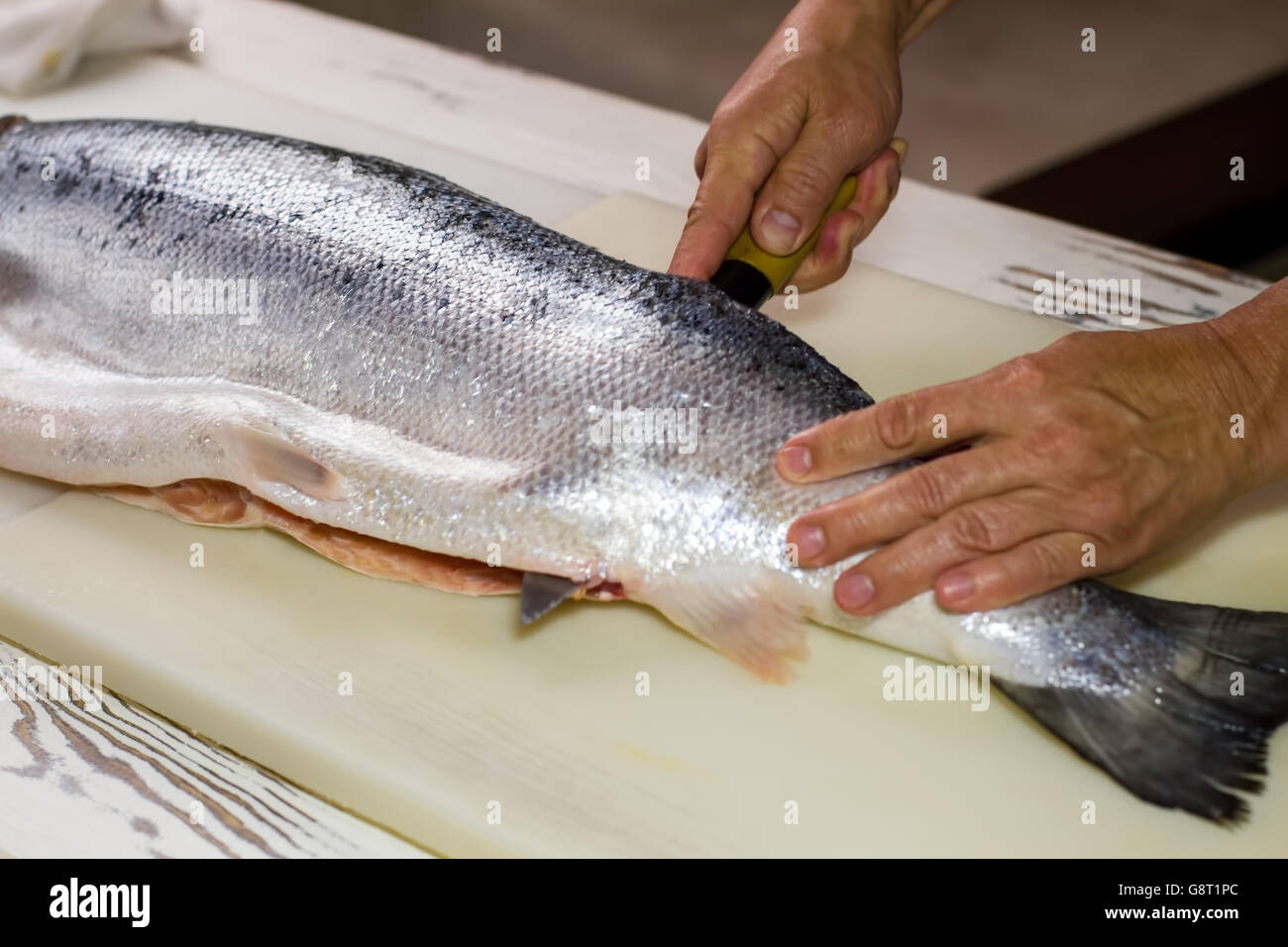 Kitchen knife cuts raw fish Stock Photo Alamy