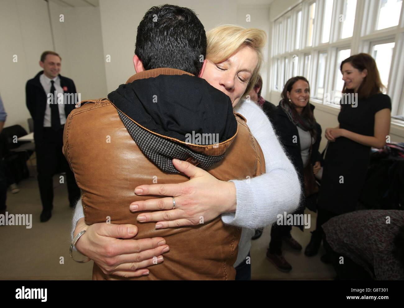 Actress Juliet Stevenson greets one of three Syrian refugees (who cannot be identified for legal reasons) at a charity in London after they arrived from Calais to the UK via the Safe Passage legal route. Stock Photo